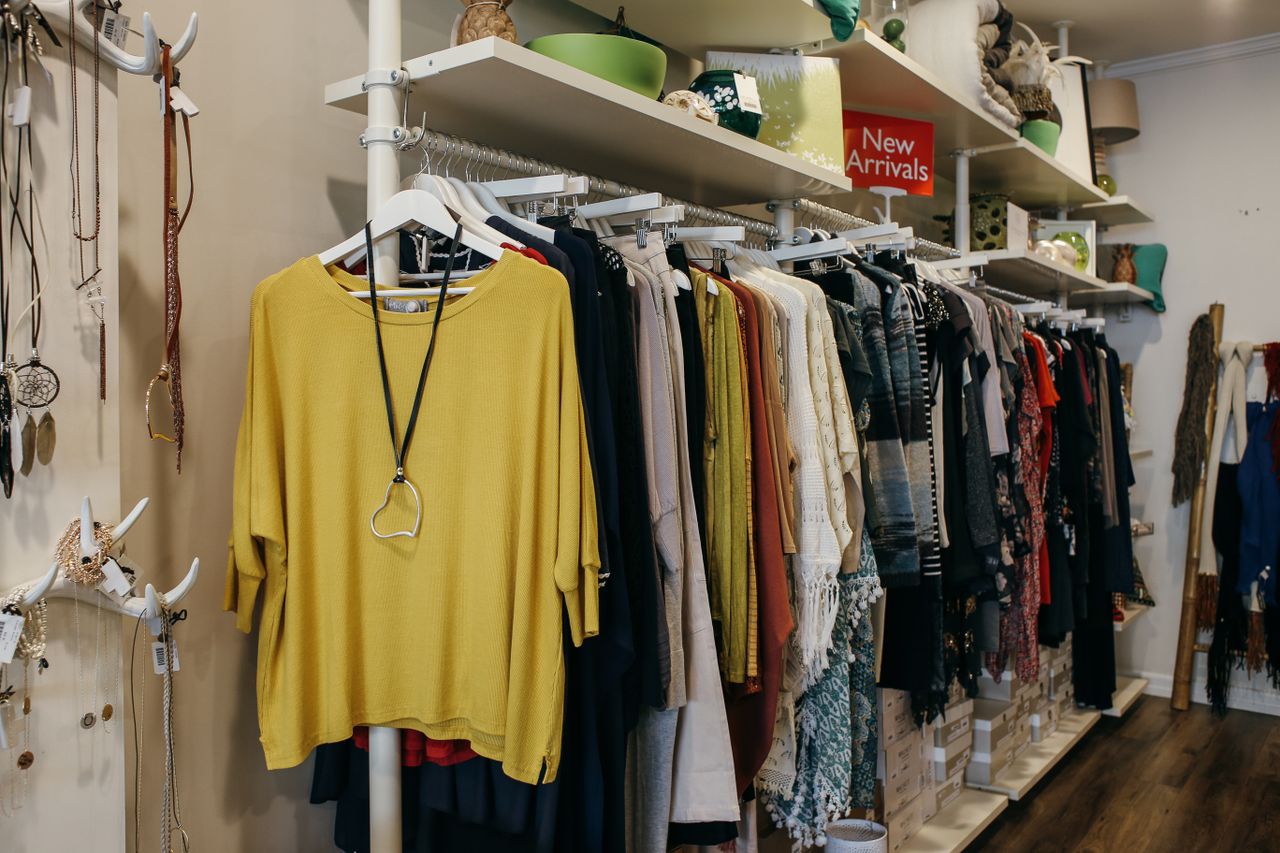 about-us Interior of a fashion boutique with clothes elegantly displayed on racks and shelves.