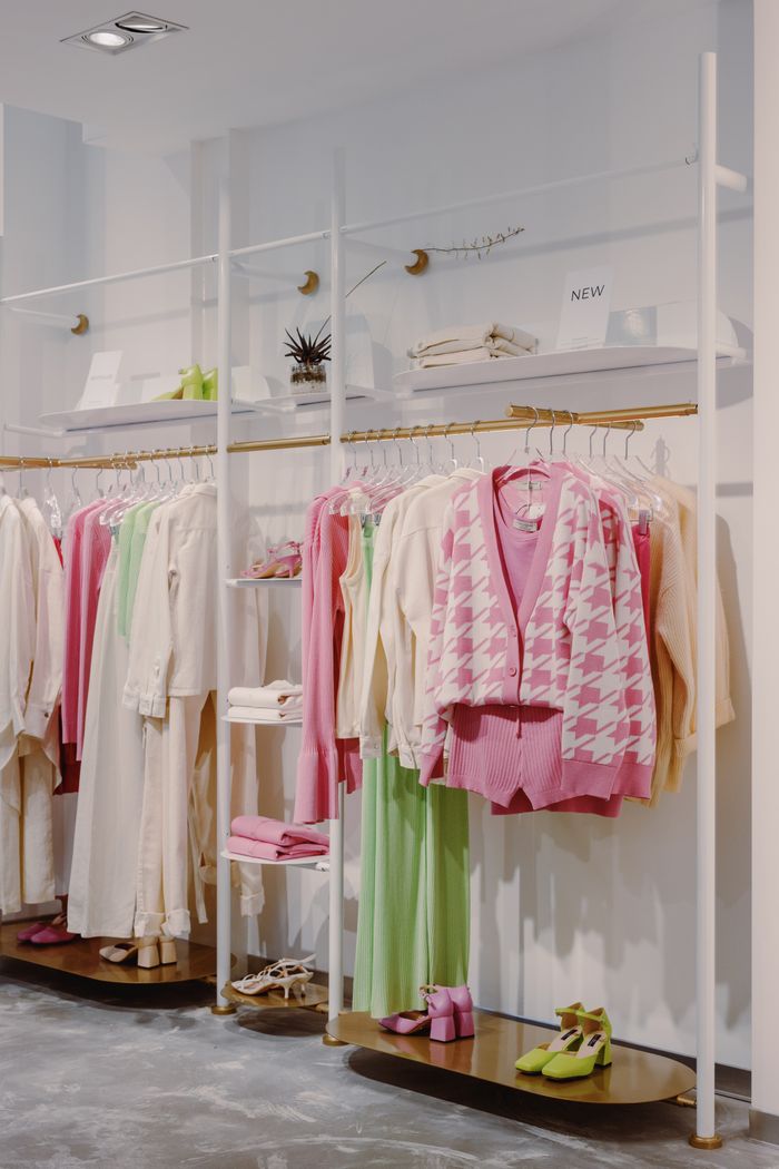 Stylish clothing display in modern boutique with colorful outfits and decor.